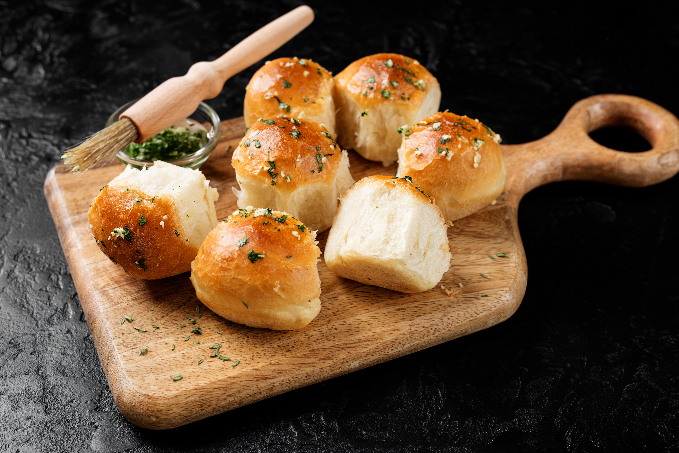 Fresh baked Homemade Garlic Butter Buns. Black background.